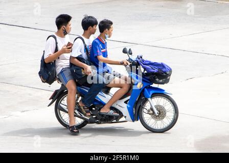 SAMUT PRAKAN, THAILAND, JUNE 26 2020, Three boys ride together on one motorcycle Stock Photo