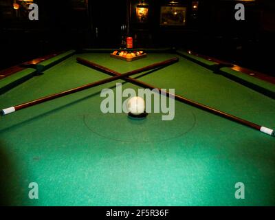 Closeup of a billiard table under the lights in a club with a blurry background Stock Photo