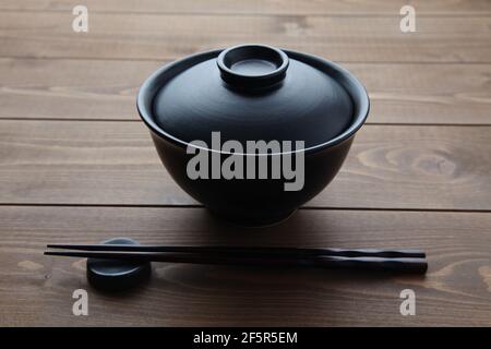 donburi rice bowl black isolated on wooden table Stock Photo