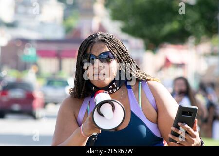 African American Woman with Braids and Sunglasses leading Black Lives Matter Protest with Megaphone Stock Photo