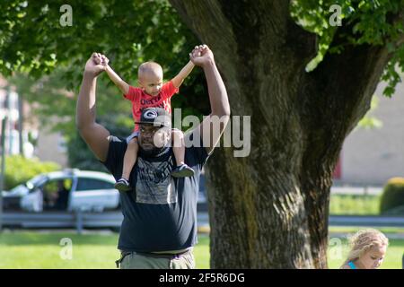 African American Dad - Father carrying Young Son or toddler at protest Stock Photo