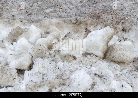 Early spring time dirty gray melted snow with sand pattern texture close-up Grunge background Stock Photo