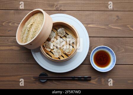 Shumai shaomai Chinese steamed meat dumpling on wooden table Stock Photo