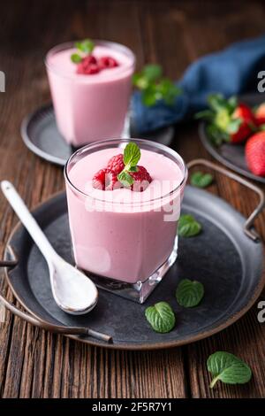 Healthy drink, strawberry and raspberry smoothie with Greek yogurt in a glass jar on rustic wooden background Stock Photo