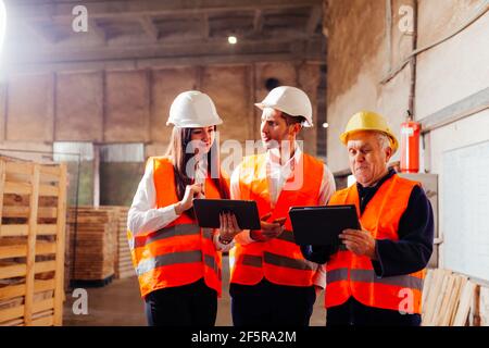 Group of engineers and workers discuss production plans Stock Photo
