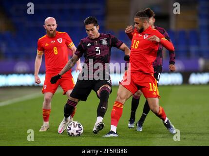 Mexico's Carlos Salcedo (centre) and Wales' Tyler Roberts battle for the ball during the international friendly at the Cardiff City Stadium, Cardiff. Picture date: Saturday March 27, 2021. Stock Photo