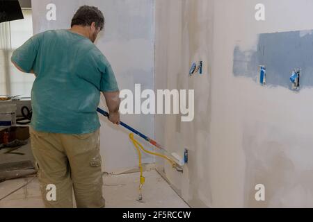 Painting of walls in a primer on white color repair in a house for painting walls Stock Photo