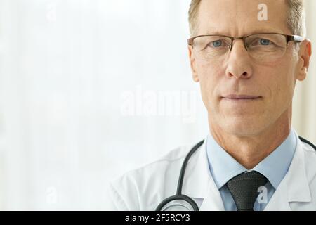 Good-looking male doctor standing against white background Stock Photo