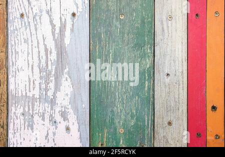 Faded orange, red and blue paint on gray weathered wood Stock Photo