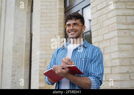 Happy asian business man writing on notebook, working project. Smiling university student studying, exam preparation, taking notes, education concept Stock Photo