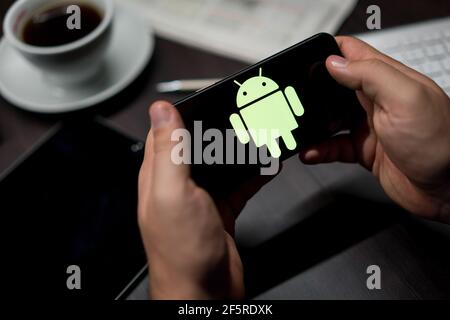 New York, New York / USA - 11 11 2019: Logo of Android on the iPhone X in hands in office Stock Photo