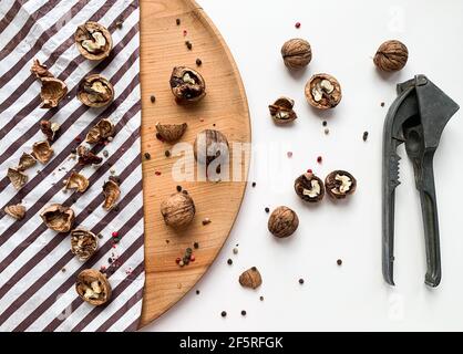 Cracked walnuts on a wooden board and white background. Stock Photo
