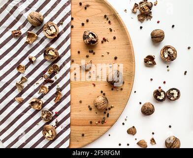 Cracked walnuts on a wooden board and white background. Stock Photo