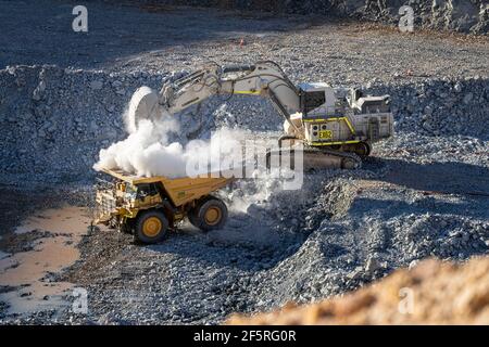 Dusty Conditions As Digger Loads Dump Truck With Ore At Gold Mine In 