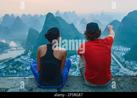 couple enjoying the view above the town of Yangshuo in China Stock Photo