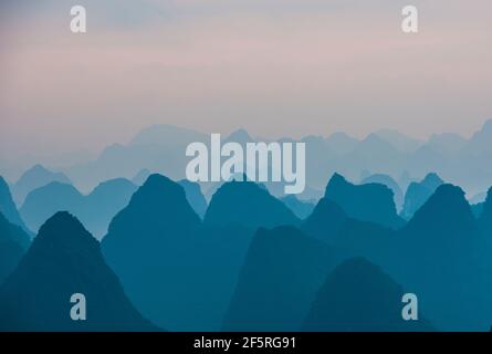 mist around limestone peaks in Yangshuo in Guangxi province / China Stock Photo