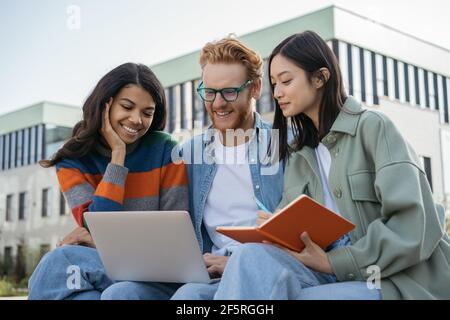 Group of multiracial university students using laptop, studying, exam preparation, education concept. Young smiling colleagues meeting, working online Stock Photo