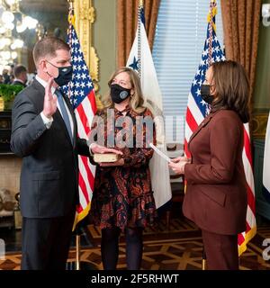 U.S. Vice President Kamala Harris, right, performs a ceremonial swearing in of Labor Secretary Marty Walsh, left, as his partner Lorrie Higgins, holds the bible at the Ceremonial Office in the Eisenhower Executive Office Building in the White House March 23, 2021 in Washington, DC. Stock Photo