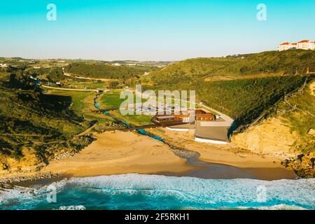 Aerial drone view of Praia de Ribeira d'Ilhas beach in Ericeira, Portugal. The Ericeira world surfing reserve Stock Photo