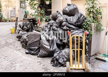 https://l450v.alamy.com/450v/2f5rn1e/garbage-bags-on-the-street-in-rome-lots-of-black-garbage-bags-waiting-to-be-taken-out-on-a-narrow-historic-street-2f5rn1e.jpg