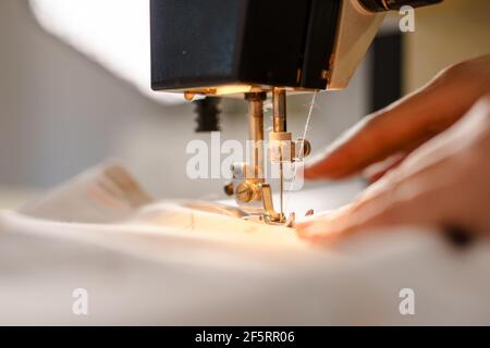 Close up on hands of unknown woman sewing on electric sewing machine Stock Photo