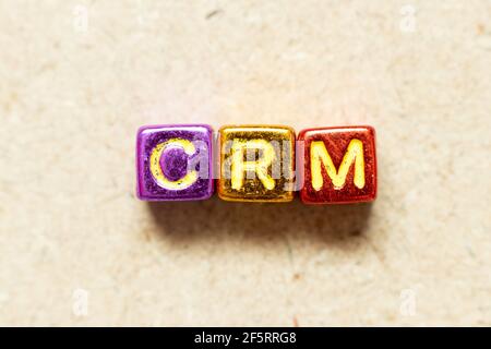 Metallic color alphabet letter block in word CRM (Abbreviation of Customer Relationship Management) on wood background Stock Photo