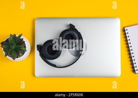 Headphones lie on notebook. Stock Photo