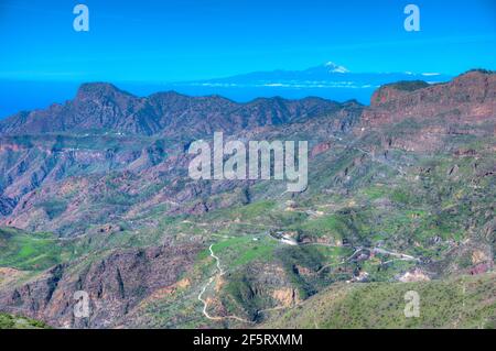 Pico de Teide viewed behind mountainous landscape of Gran Canaria, Canary Islands, Spain. Stock Photo