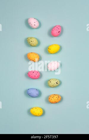 Easter colorful eggs in the form of two tracks on a blue background. Top view. Stock Photo