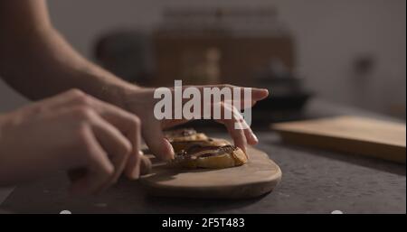 Man spreading chocolate hazelnut spread on baguette slices, wide photo Stock Photo