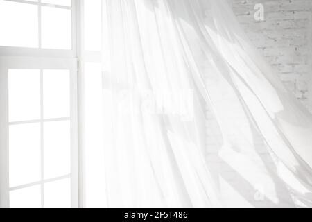Backlit window with white curtains in empty room Stock Photo