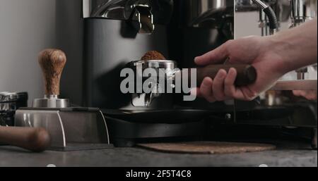 man grinding fresh coffe in single spout portafilter with professional grinder, wide photo Stock Photo