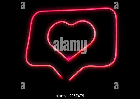 Neon light pink heart love in chat bubble box isolated grow in the dark background. Stock Photo