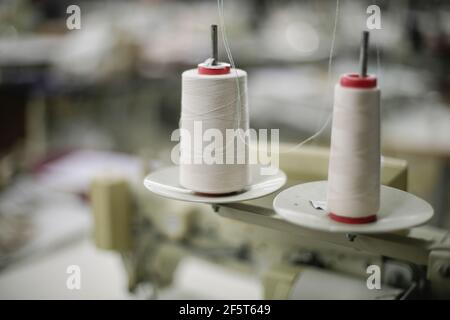 Shallow depth of field (selective focus) image with thread spools in a textile factory. Stock Photo