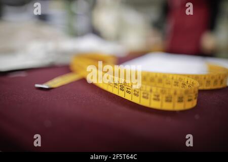 Shallow depth of field (selective focus) image with a tailor’s metre in a textile factory. Stock Photo