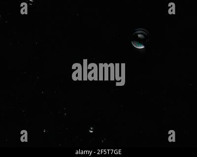 Bubbles on the surface of the liquid. Abstract Black Background Liquid Texture. Stock Photo
