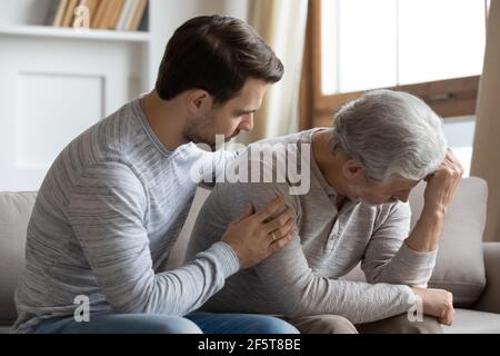 Loving adult son support sad elderly father Stock Photo