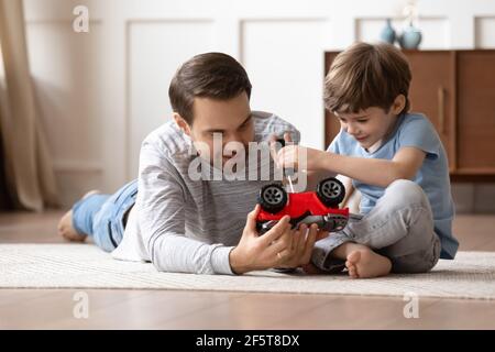 Playful Caucasian father repair car with little son Stock Photo