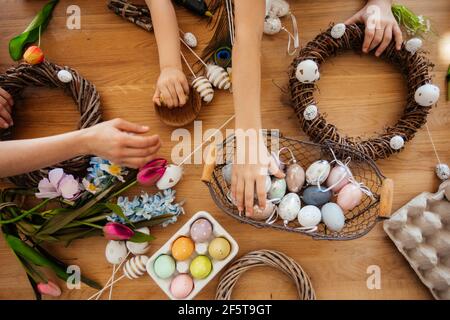 Making homemade Easter wreath of vines decorated with eggs Stock Photo