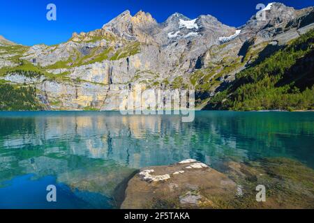 Picturesque travel and tourism location, beautiful alpine lake and stunning snowy mountains with glaciers in background, Oeschinensee lake, Bernese Ob Stock Photo