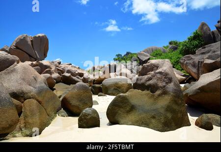 Anse Marron beach with big granite boulders on La Digue Island, Seychelles. Tropical landscape with sunny sky. Exotic travel destination. Stock Photo
