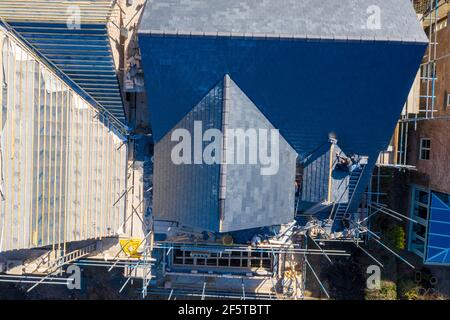 Aerial photo of building construction work being done on a property with scaffolding up at the property and roofers working on the roof of the house p Stock Photo
