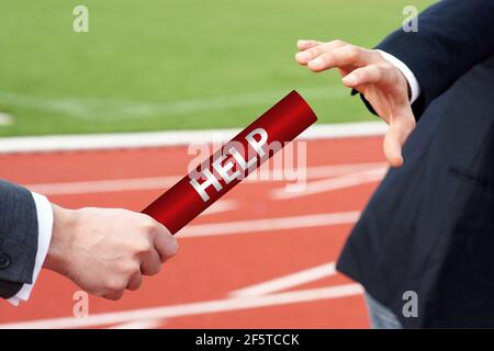 Businessmen pass help assistance baton in relay race in stadium Stock Photo
