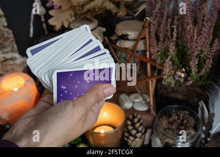 Woman hand is holding deck of tarot or oracle cards doing fortunetelling. Stock Photo