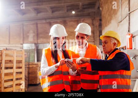 Group of engineers and workers discuss production plans Stock Photo