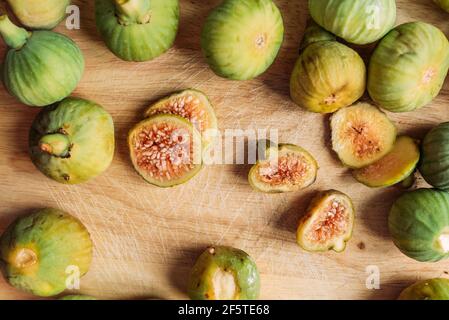Ripe sweet green figs, freshly harvested from domestic tree on wood cutting board. Also known as ripe white figs Stock Photo
