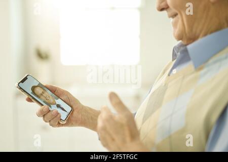Eldelry man reporting on well-being to family doctor via phone Stock Photo