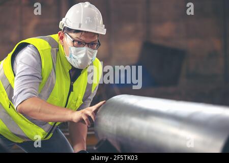 Engineers examine new coated pipe in factory, Ventory Check Stock Photo