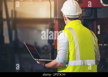 engineer man, or technicians wearing surgical mask and using computer notebook for Checking Stock Photo