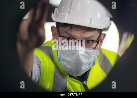 Engineers examine new coated pipe in factory, Ventory Check Stock Photo